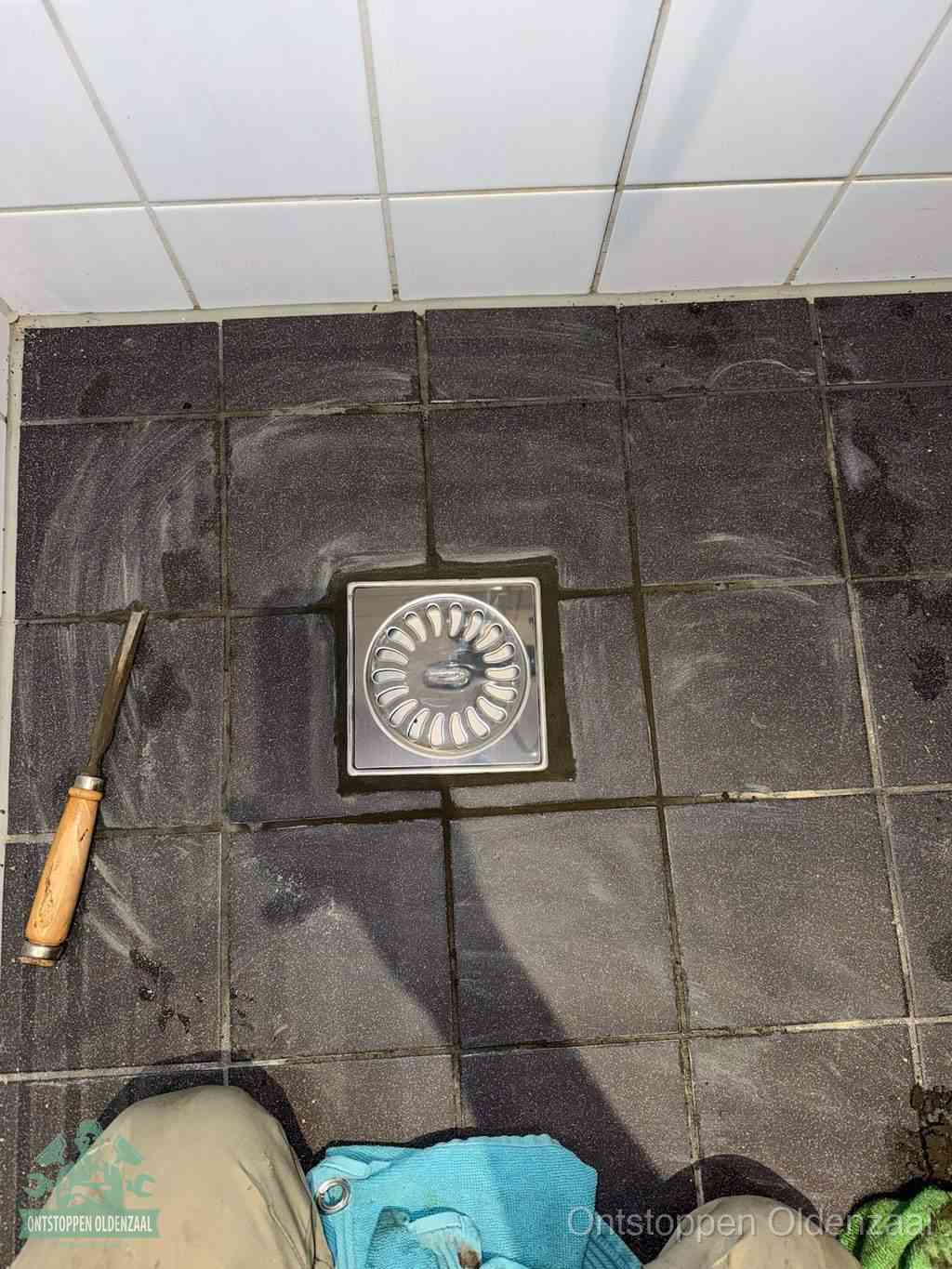 Een RVS doucheputje in een betegelde badkamervloer, zelf je badkamer ontstoppen in Oldenzaal