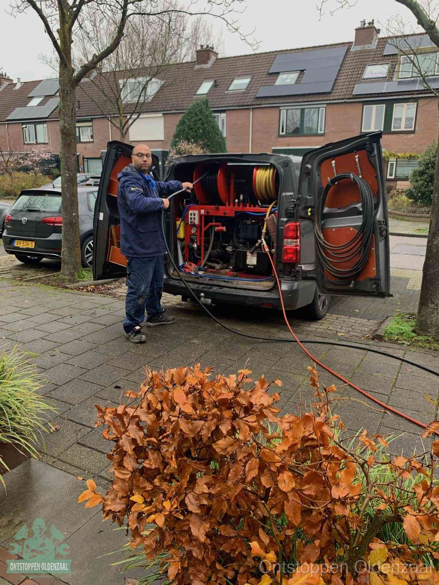 Een monteur staat bij zijn open bestelbus met hogedruk-rioolreinigingsapparatuur, klaar om binnen 30 minuten uit te rukken voor een spoedverstopping in Oldenzaal
