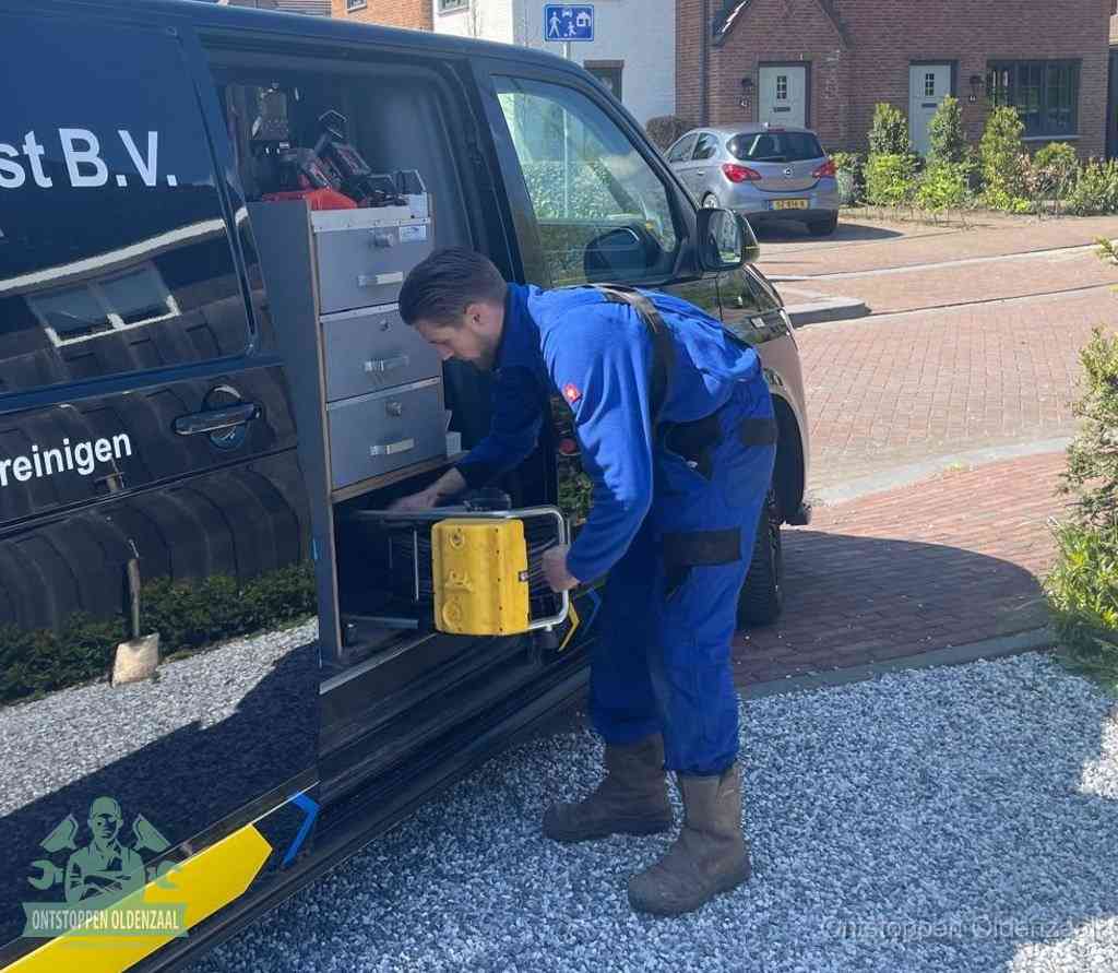 Een monteur pakt gereedschap uit de bedrijfsbus, het moment om een professionele ontstoppingsdienst in te schakelen in Oldenzaal