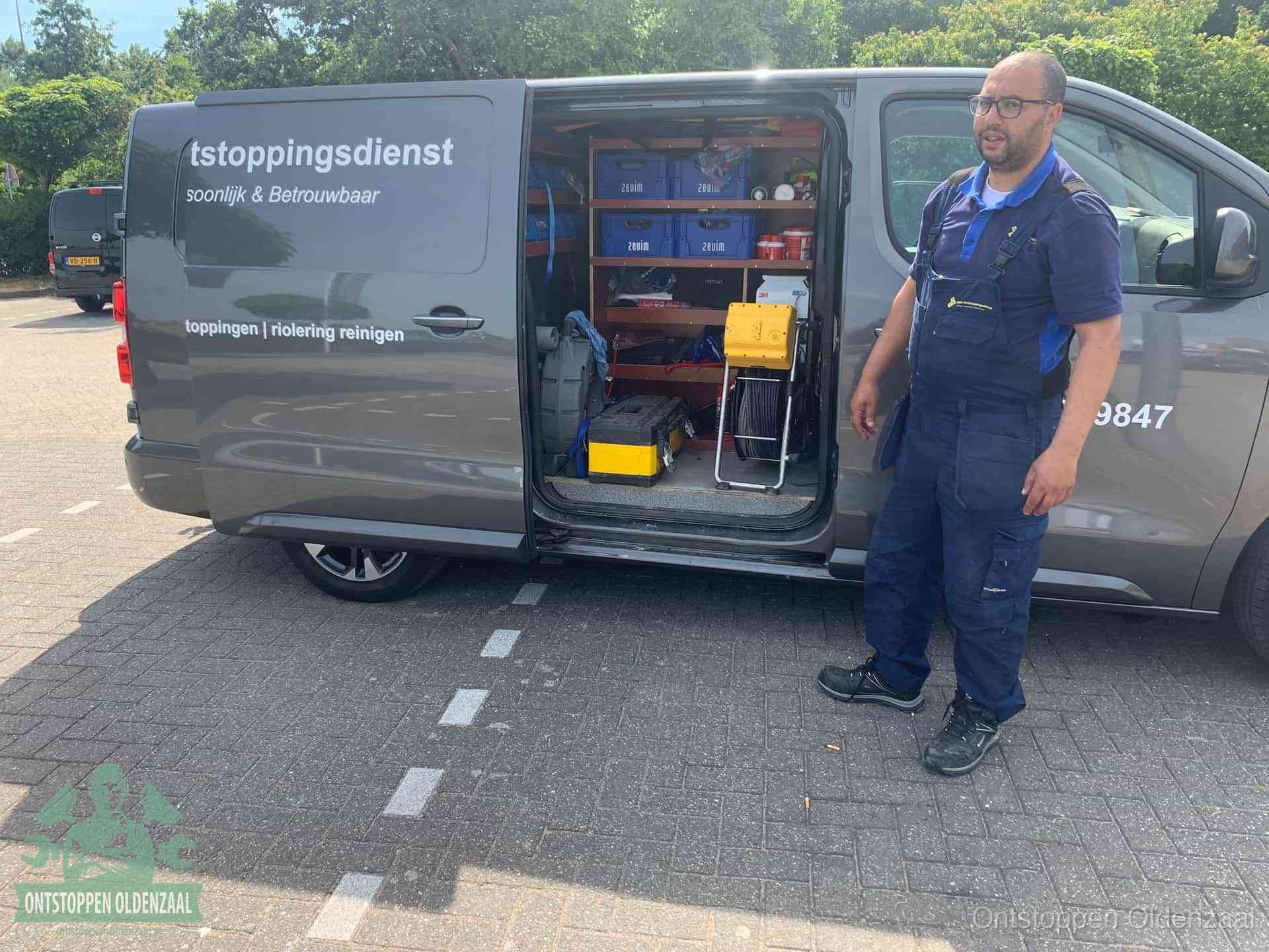 Een monteur staat klaar bij zijn bedrijfsbus met gereedschap, de vaste werkwijze van de ontstoppingsdienst in Oldenzaal
